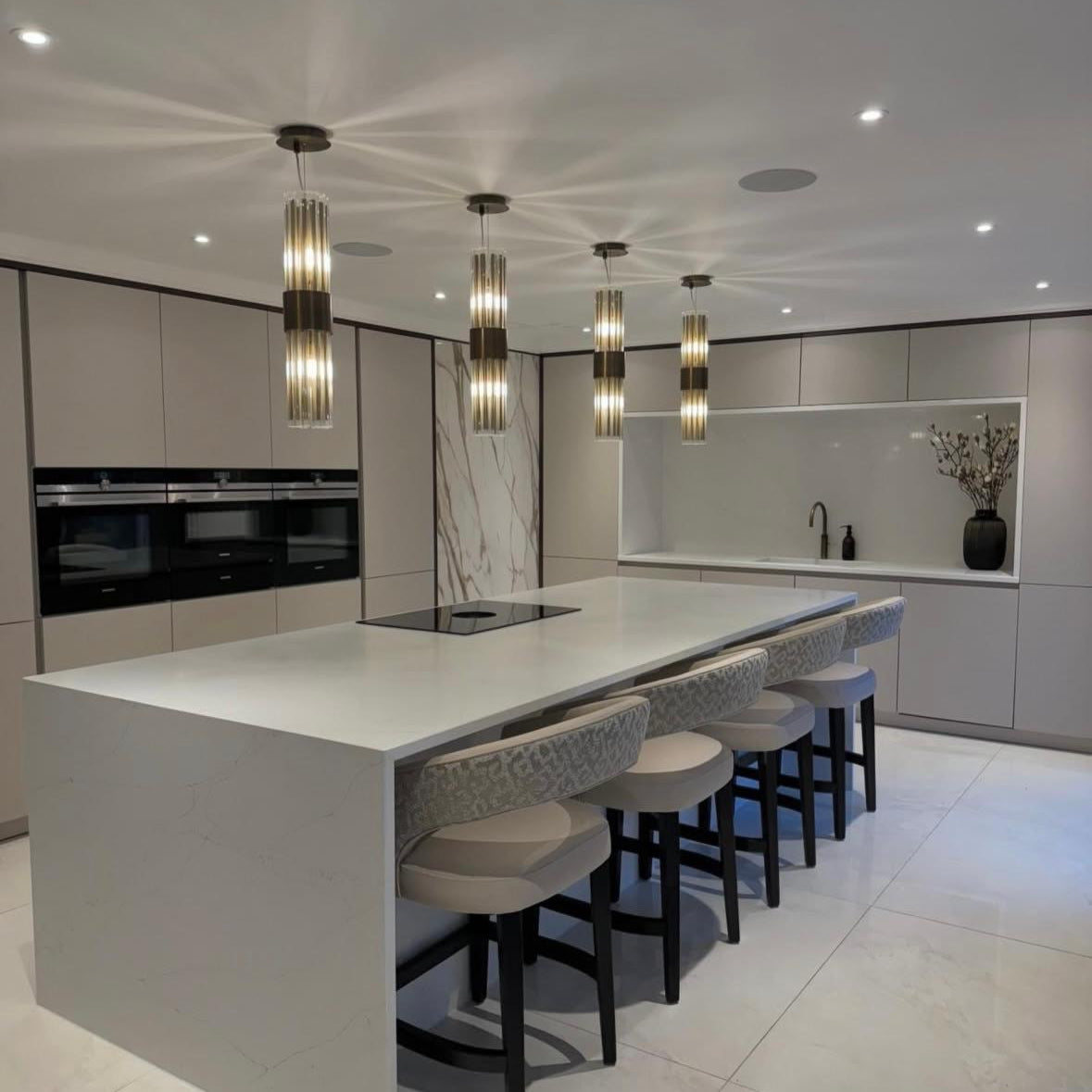 Modern crystal pendant lights enhancing open plan kitchen with warm ambient lighting