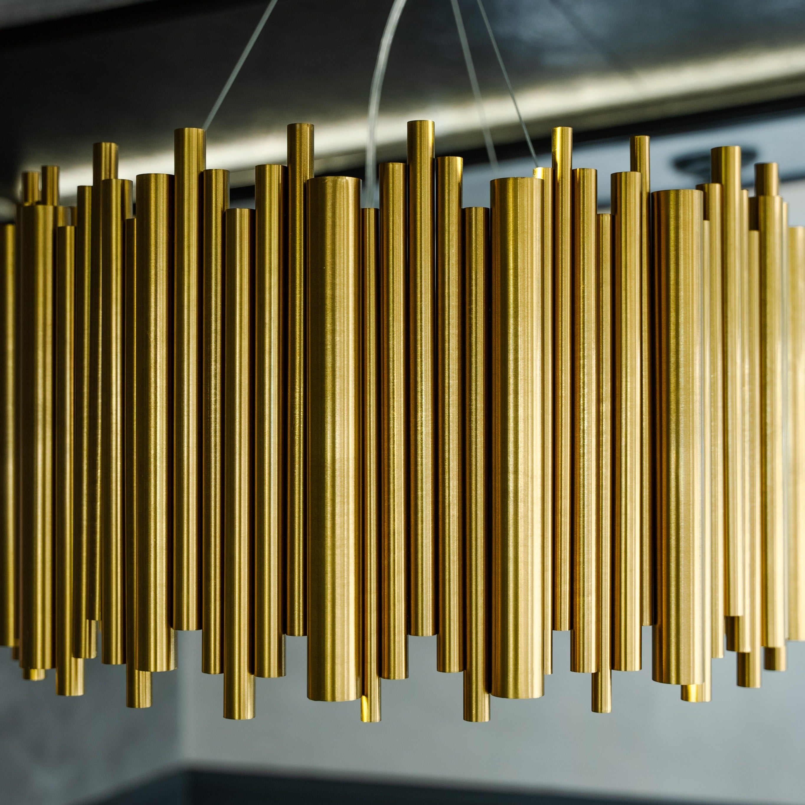 Circular chandelier with vertical tube design enhancing luxury lounge interior with warm lighting