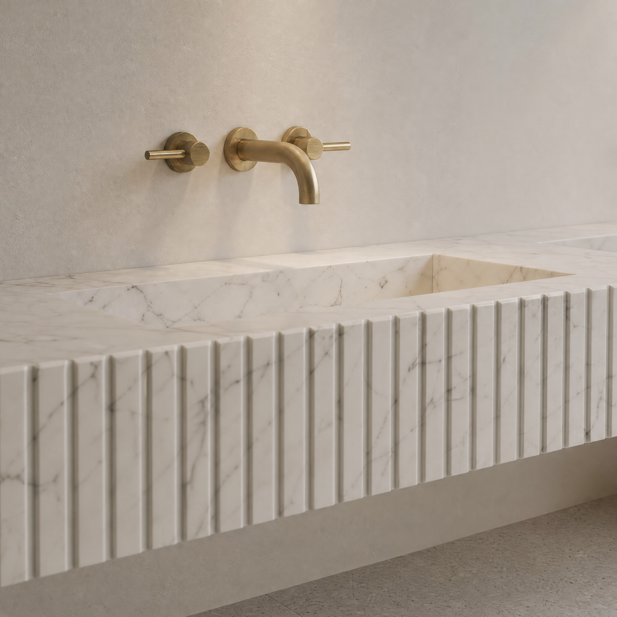 Close-up shot of the architectural fluted front design and natural feathered veining on the White Carrara marble double sink.