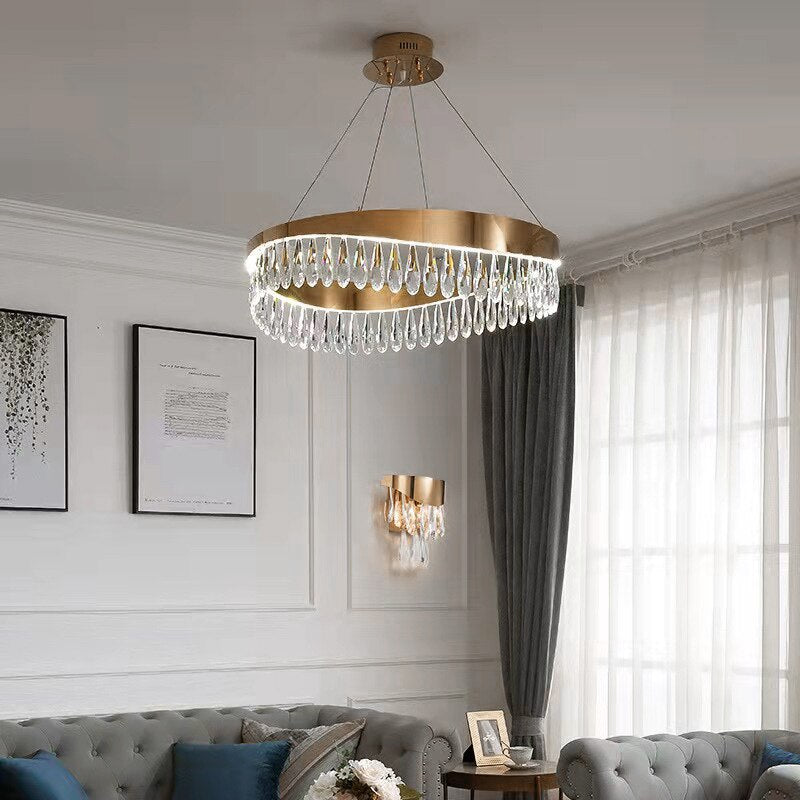 Luxury circular chandelier with cascading teardrop crystals illuminating an elegant contemporary living room