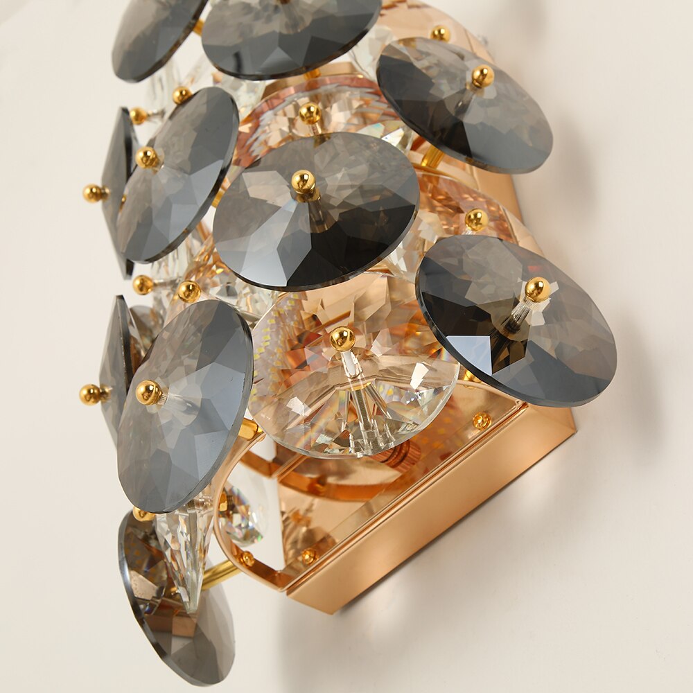 Decorative arrangement of smoky and clear crystal discs forming a luxury wall light design