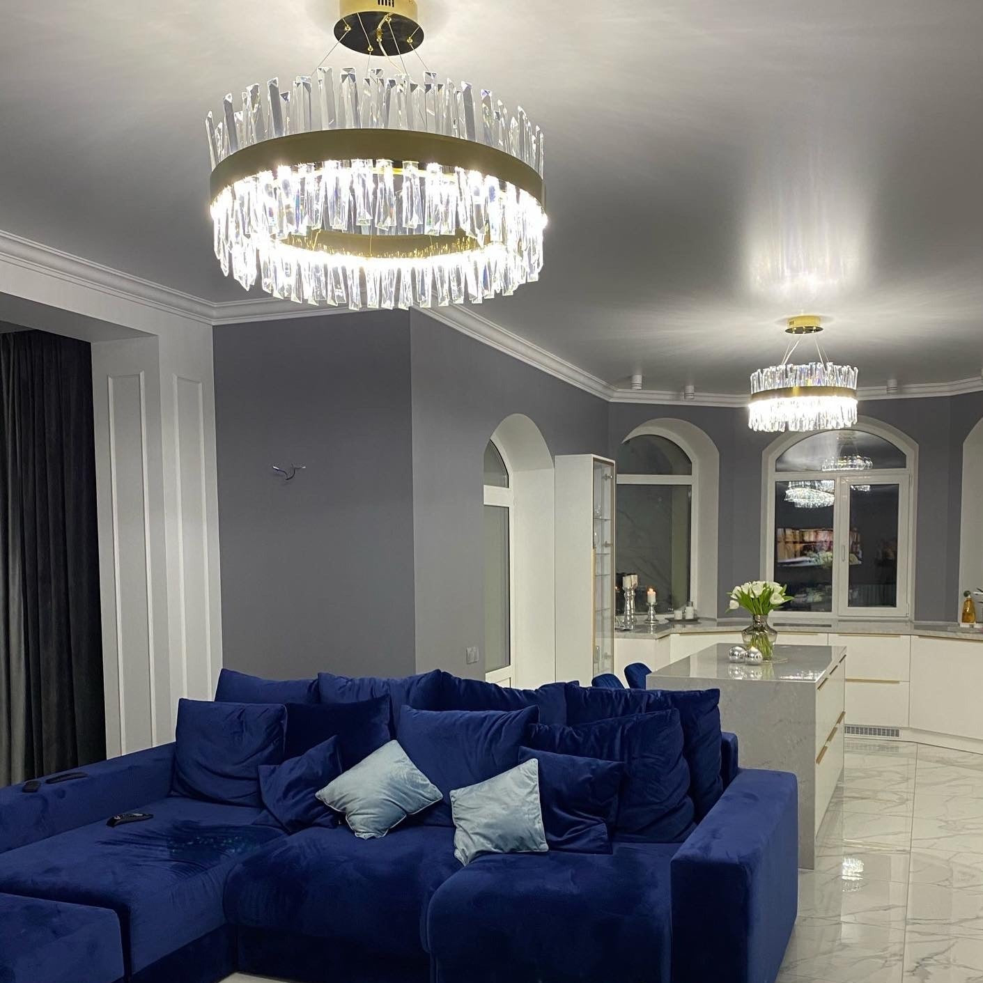 Luxury circular crystal chandelier illuminating an elegant living room with contemporary styling
