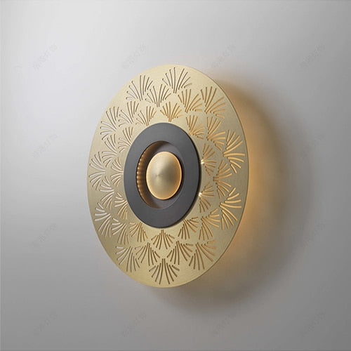 Close up of radial patterned circular plate on Piatto Series decorative wall light highlighting sculpted surface texture