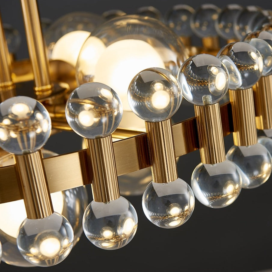 Alytus pendant crystal detail with gold elements and reflective clear crystals in dark setting.