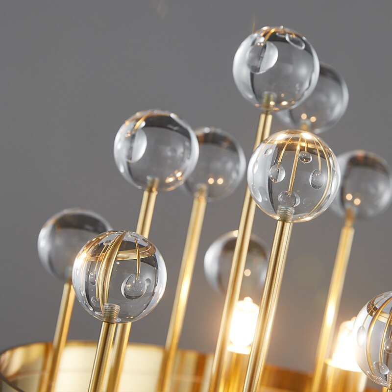 Close-up view showing the delicate clear glass spheres and sleek gold frame of the Alytus Table Lamp.