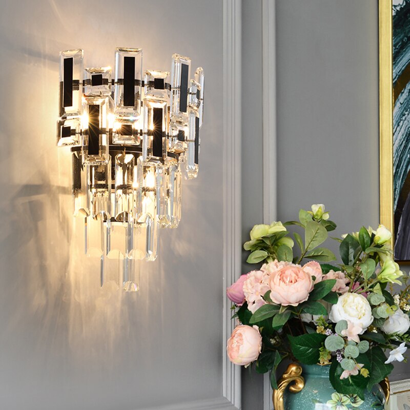 Belvedere crystal wall light casting a warm glow in an elegant room setting.