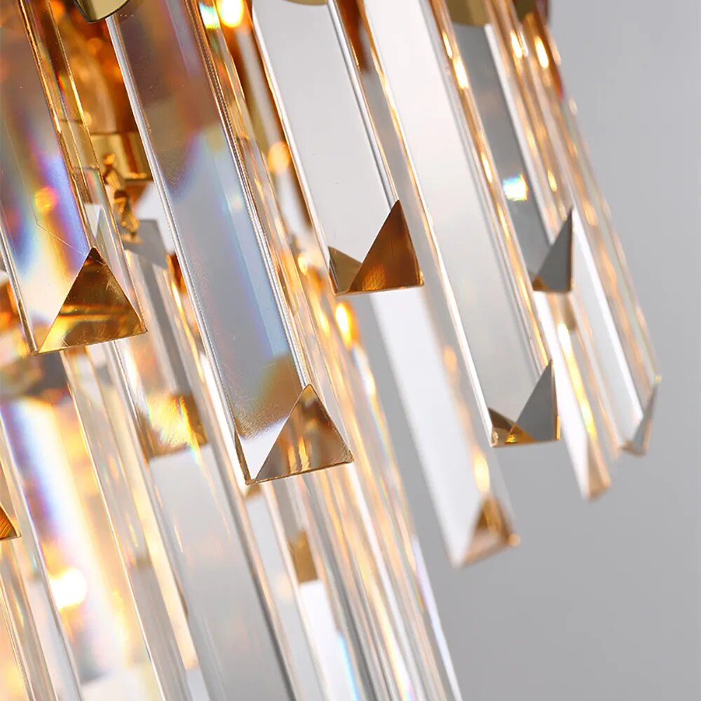 Macro detail of VORELLI Manhattan Pendant II diamond-cut crystal bars glowing with warm light
