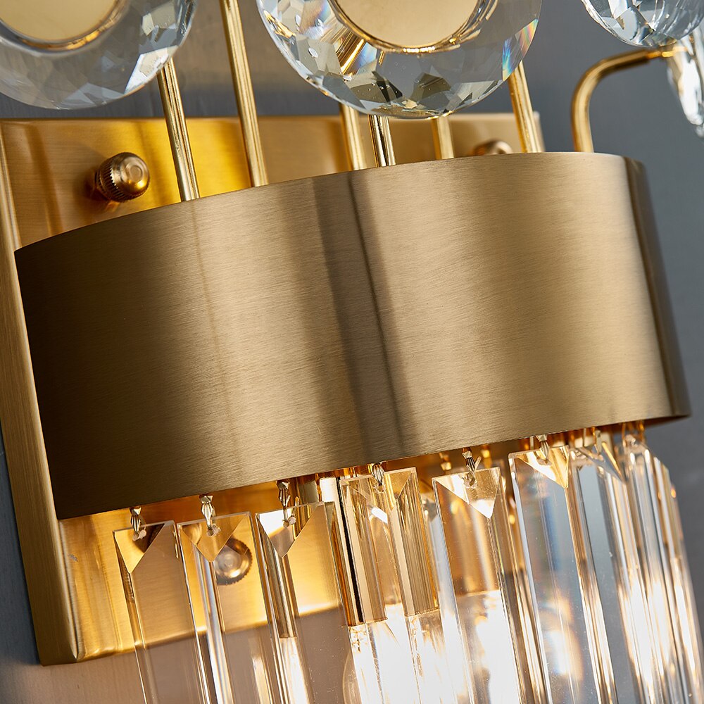 Close up of structured band frame and diamond cut crystal discs on VORELLI® Patara Wall Light II