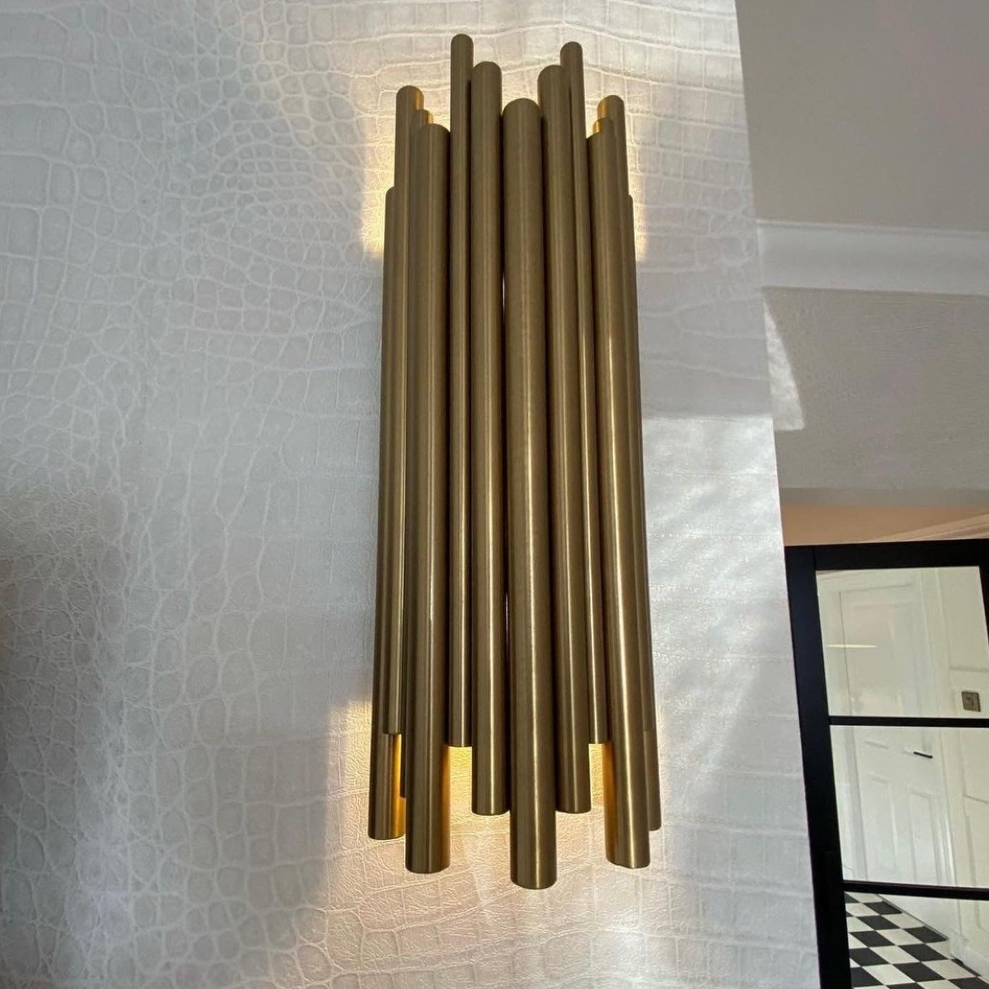 Contemporary wall light with vertical tube structure creating architectural lighting effect